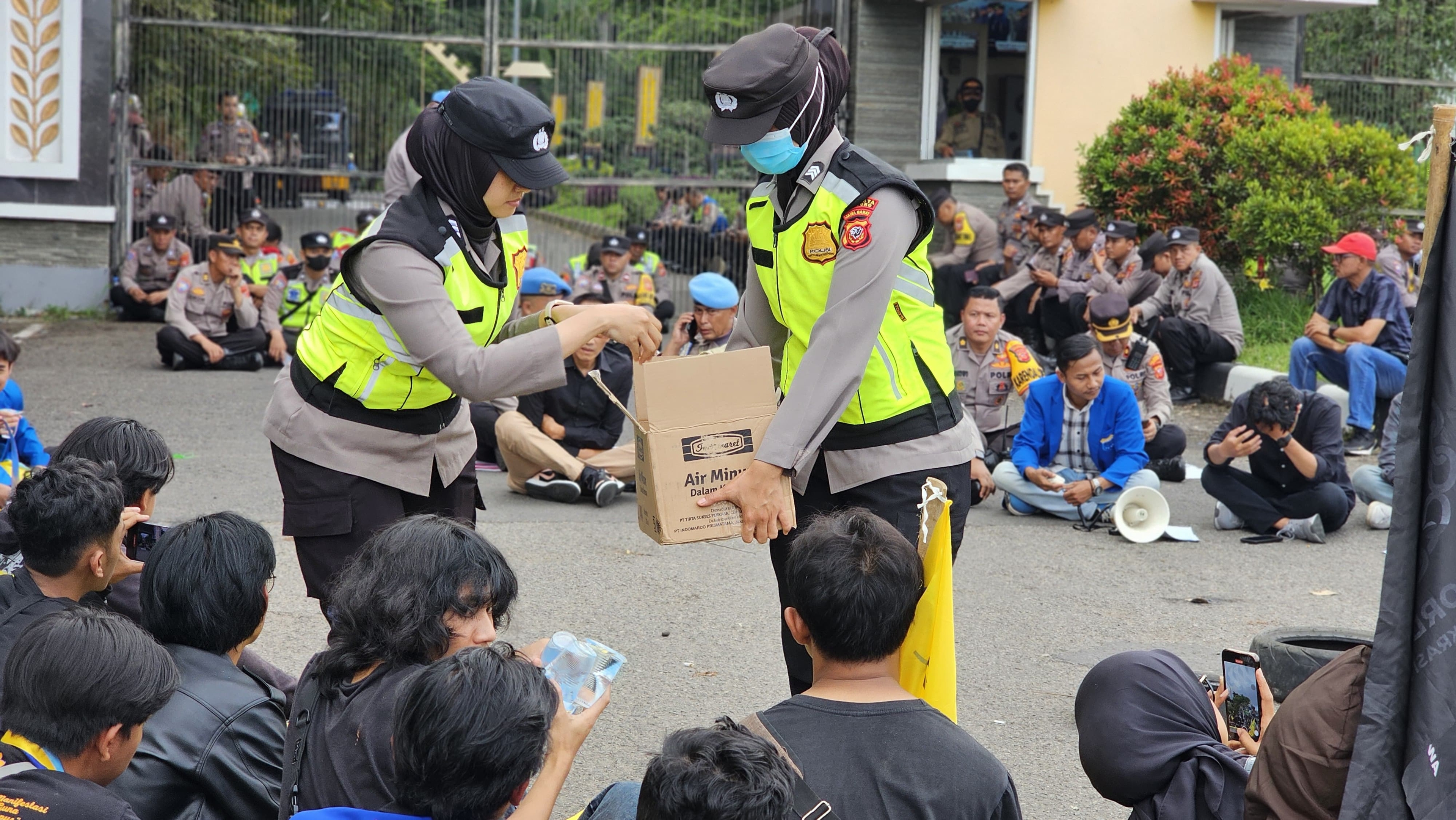 Polwan Polresta Bandung Bagikan Air Mineral Kepada Peserta Demo